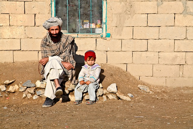 An Afghan man sitting with his daughter.